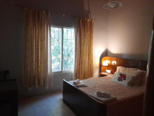 a bedroom with a bed with a large window at Casita de Frasca in San José de Jáchal