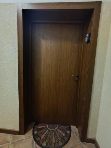 a wooden door with a rug in front of it at Studio in Murphys Lodge in Bansko