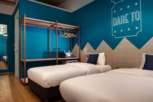 two beds in a room with blue walls at Colors Urban Hotel Thessaloniki in Thessaloniki