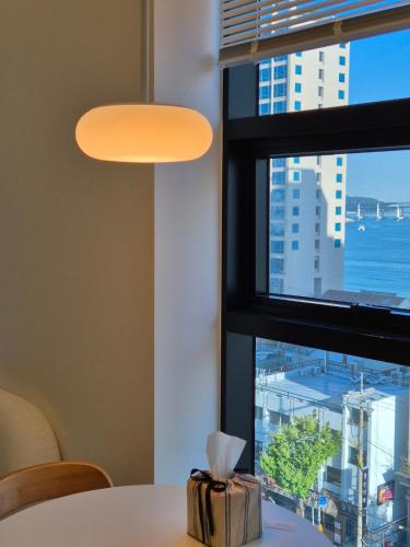 a table with a cake on it next to a window at 로프트부산 loft busan in Samgong