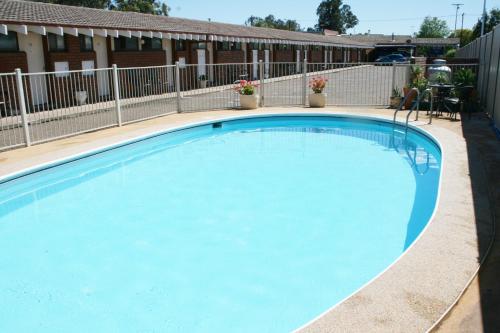 a large blue swimming pool in front of a building at The Plains Motor Inn in Gunnedah
