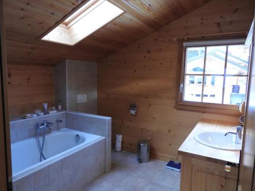 a large bathroom with a tub and a sink at Chalet Le Murier in Leysin
