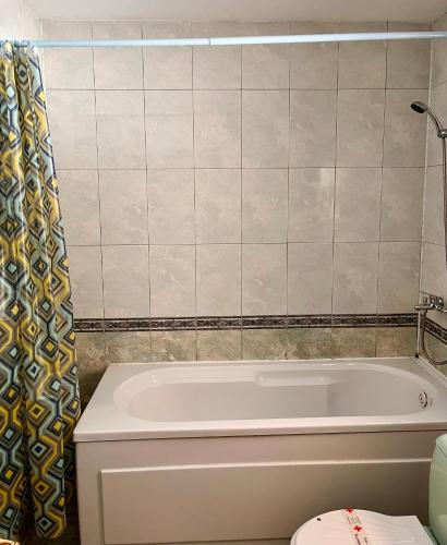 a bathroom with a tub and a toilet at Hotel Restaurant Vodenitsata in Berkovitsa