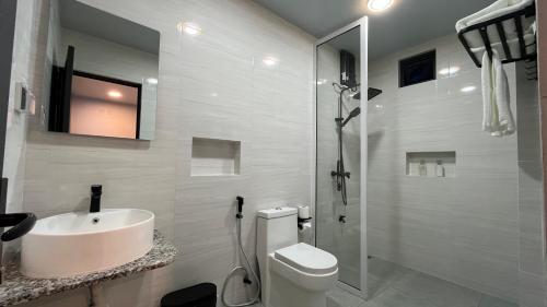 a bathroom with a sink and a toilet and a shower at Ahiva Suites Goidhoo in Fehendhoo