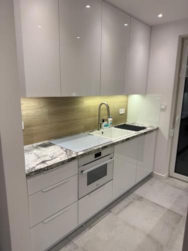 a kitchen with white cabinets and a sink at Homestay in Dąbrowa Górnicza