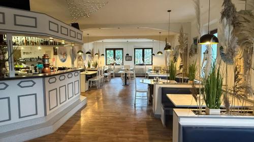 a restaurant with a bar and some tables and chairs at Strand-Hotel Lobbe in Lobbe