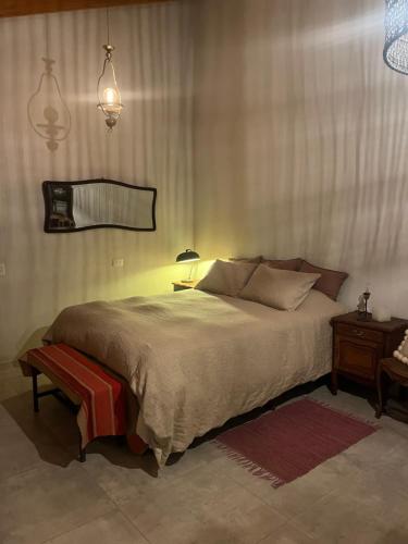 a bedroom with a large bed with a lamp and a table at Villa Paula II in Ranchos
