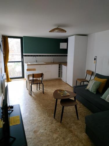 a living room with a couch and a table at Appartement meublé, Le 37bis in Bolbec