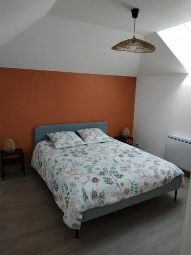 a bedroom with a bed with a floral comforter at Appartement meublé, Le 37bis in Bolbec