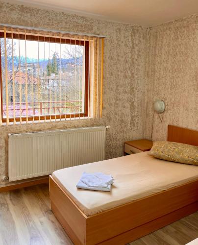a bedroom with a bed and a large window at Hotel Restaurant Vodenitsata in Berkovitsa