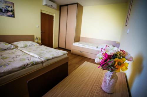a bedroom with a bed and a vase of flowers on a table at Vendelin Apartmany in Bojnice