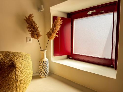 a vase sitting next to a window with flowers in it at Arbarorisa Traditional Suites in Mesaria