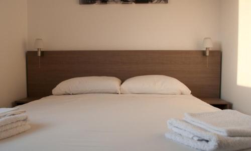 a bedroom with a bed with two towels on it at St. George Rent Rooms in Larnaka