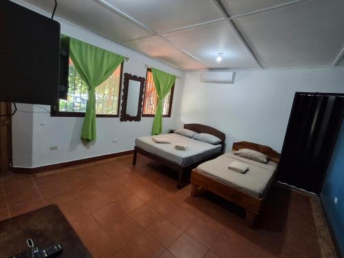 a room with two beds and a tv in it at Hotel Marielos Tamarindo in Tamarindo