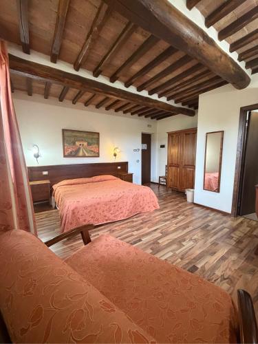 a bedroom with two beds and a wooden floor at B&B Fonte dei Tufi in Siena