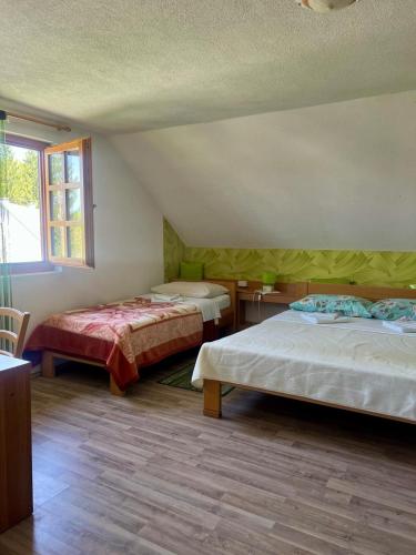 a bedroom with two beds and a window at Adriana Guesthouse in Jezerce