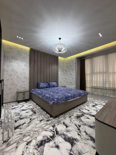 a bedroom with a large bed and a chandelier at White Guest House in Samarkand