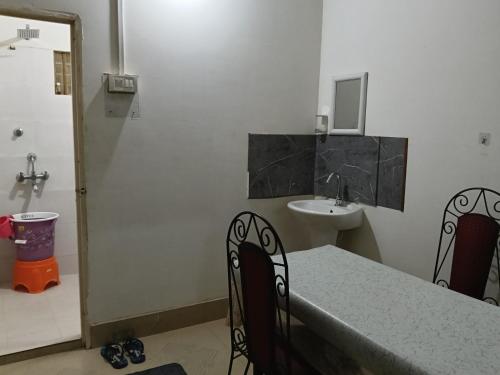 a room with a table and a sink and a bathroom at Bijoy Villa in Guwahati