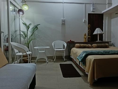 a bedroom with two beds and a table and chairs at Bijoy Villa in Guwahati
