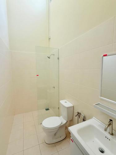 a bathroom with a toilet and a shower and a sink at Jinta House Cherating in Kampong Baharu
