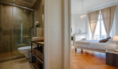 een slaapkamer met een bed en een badkamer met een douche bij Appartement Vaste Horizon - LRA Cannes in Cannes