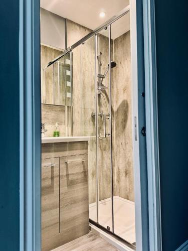 a bathroom with a shower with a glass door at Lochwood House & The Wild Spa in Lochgoilhead