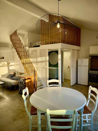 a dining room with a table and a staircase at Grand studio avec terrasse in Saint-Marcel-lès-Valence