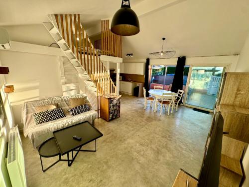 a living room with a staircase and a table at Grand studio avec terrasse in Saint-Marcel-lès-Valence