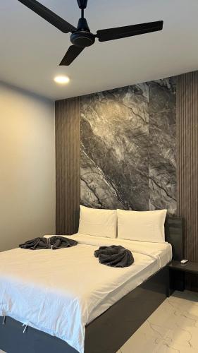 a bedroom with a bed with a ceiling fan at Ahiva Suites Goidhoo in Fehendhoo