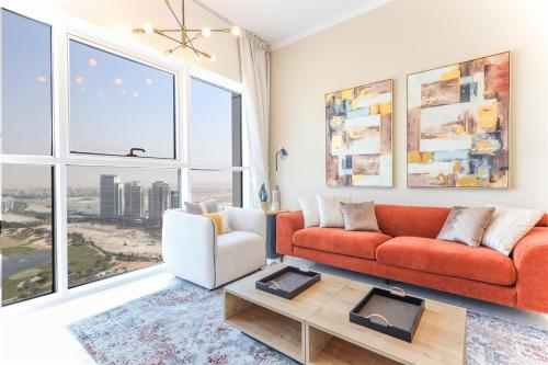 a living room with a red couch and a large window at Elite LUX Holiday Homes - Serene Golf View Living 1 BHK in Damac Hills, Dubai in Dubai