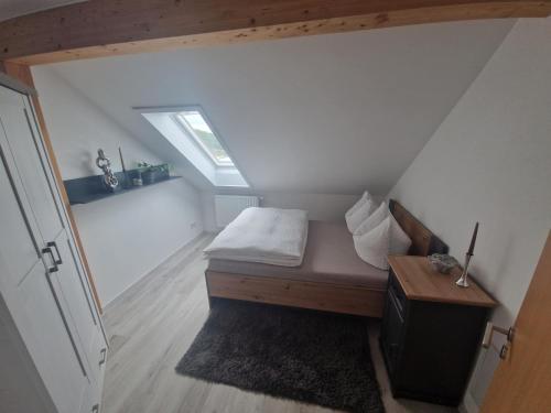 a small attic room with a bed and a window at Moderne Ferienwohnung in Hainichen in Hainichen
