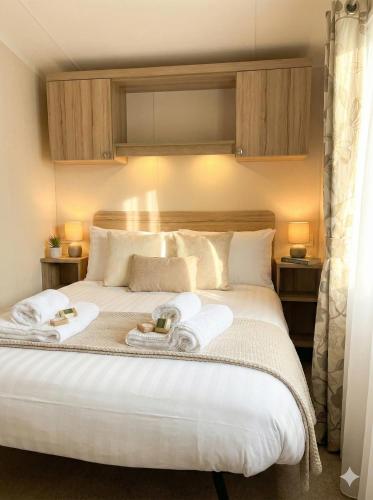 a bedroom with a large bed with towels on it at Sunset Bay Aberaeron in Aberaeron