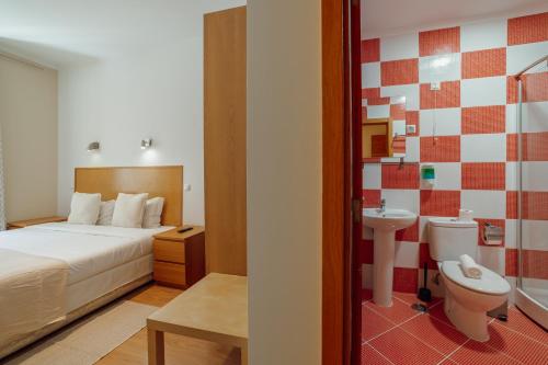 a bedroom with a bed and a toilet and a sink at DownTown Guest House in Lisbon