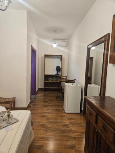 a room with a bed and a table and a mirror at Pousada Berço Mineiro in Tiradentes