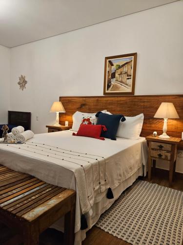a bedroom with a large bed with pillows on it at Pousada Berço Mineiro in Tiradentes