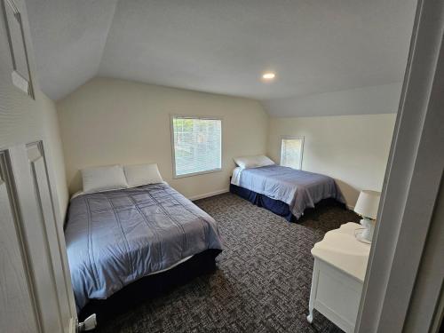a bedroom with two beds and a table with a night stand at Moores Crystal Mountain Retreat in Thompsonville