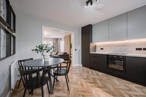 a kitchen with a table and chairs in a kitchen at JW Canmore ApartHouse in Glasgow