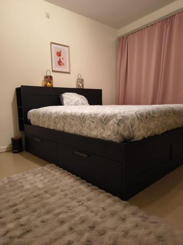 a bedroom with a large bed with a black frame at Namur cozy apartment in Namur