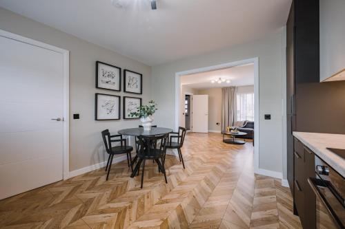 a kitchen and dining room with a table and chairs at JW Canmore ApartHouse in Glasgow