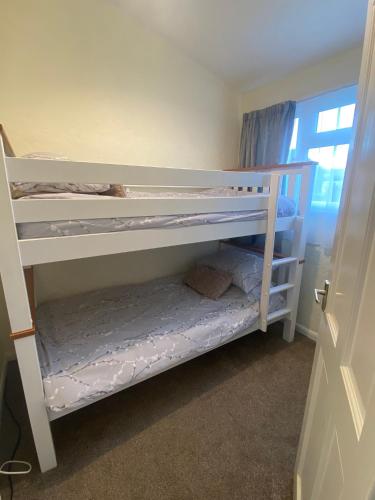 two bunk beds in a room with a window at Chateau Seaside in Withernsea