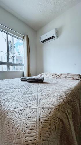 a bedroom with a large bed and a window at Apartamento completo com lazer in João Pessoa