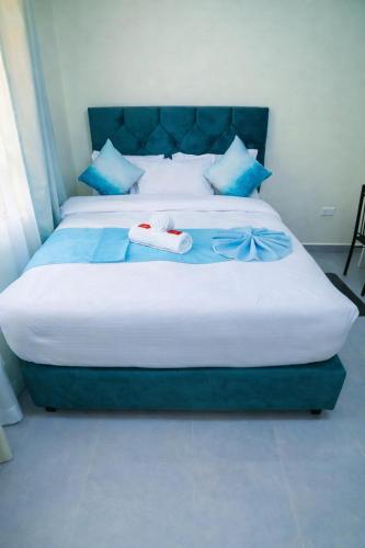 a bedroom with two beds with blue pillows at GLOW Suites in Naivasha