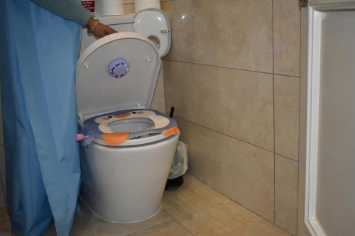 a bathroom with a toilet with the lid up at Secret Villa - Room Rose in Taʼ Lampuka