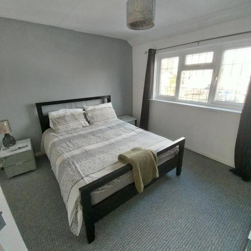 a bedroom with a bed and a window at Make It Your Home in Wednesfield