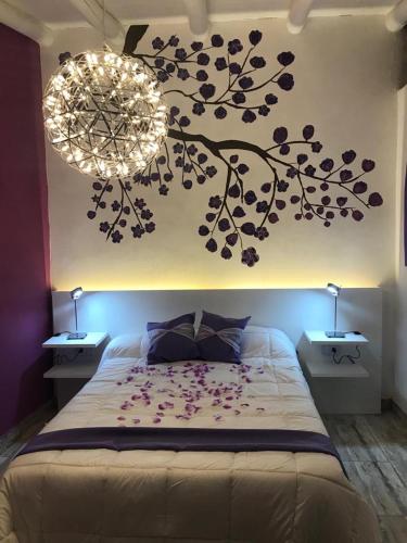 a bedroom with a bed with a tree mural on the wall at La Posada de Sofi in Concordia
