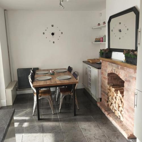 a dining room with a table and a fireplace at Make It Your Home in Wednesfield