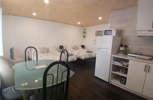 a small kitchen with a table and a white refrigerator at Habitations Zenith in Sainte-Anne-de-Beaupré