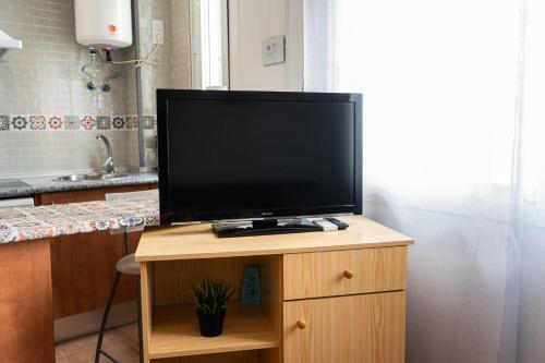 a flat screen tv sitting on top of a wooden cabinet at Luz del Guadiana in Ayamonte