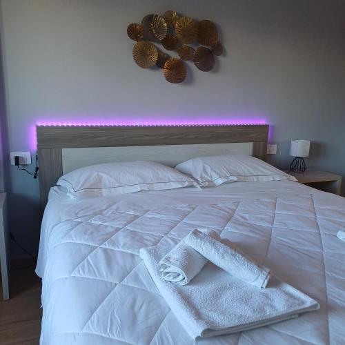 a white bed with two towels on top of it at Luxury Rooms Bari in Bari