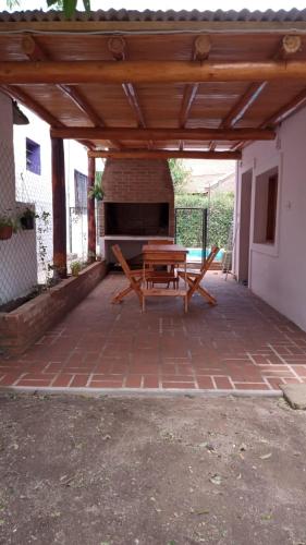 a patio with a picnic table under a wooden pergola at casitadearminda-II in Villa Las Rosas